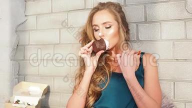 一个年轻女人在床上吃着果酱馅饼。卷发美女享受早饭